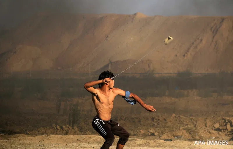 Palestinian protesters gather during clashes with Israeli troops in tents protest where Palestinians demand the right to return to their homeland at the Israel-Gaza border, in al-Bureij in the center of Gaza Strip on Sep...