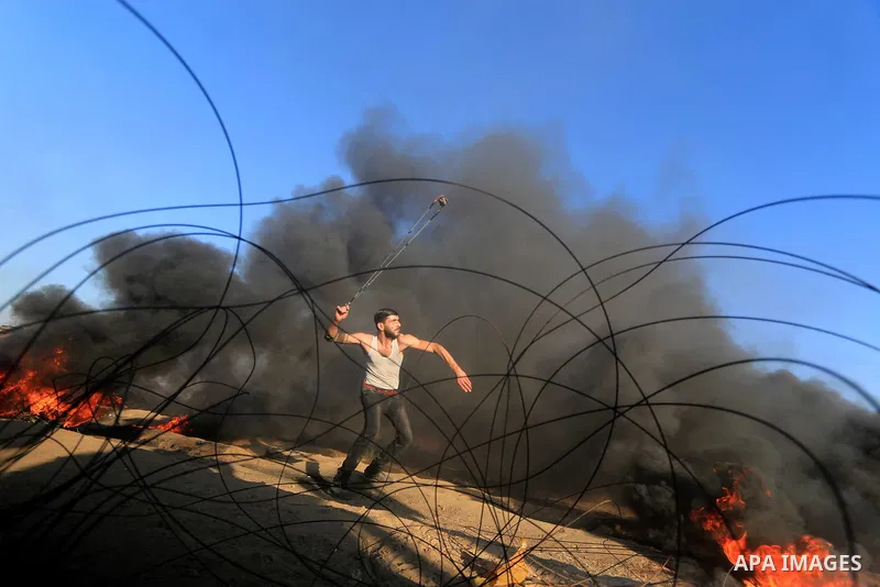 Palestinian protesters gather during clashes with Israeli troops in tents protest where Palestinians demand the right to return to their homeland at the Israel-Gaza border, in al-Bureij in the center of Gaza Strip on Sep...