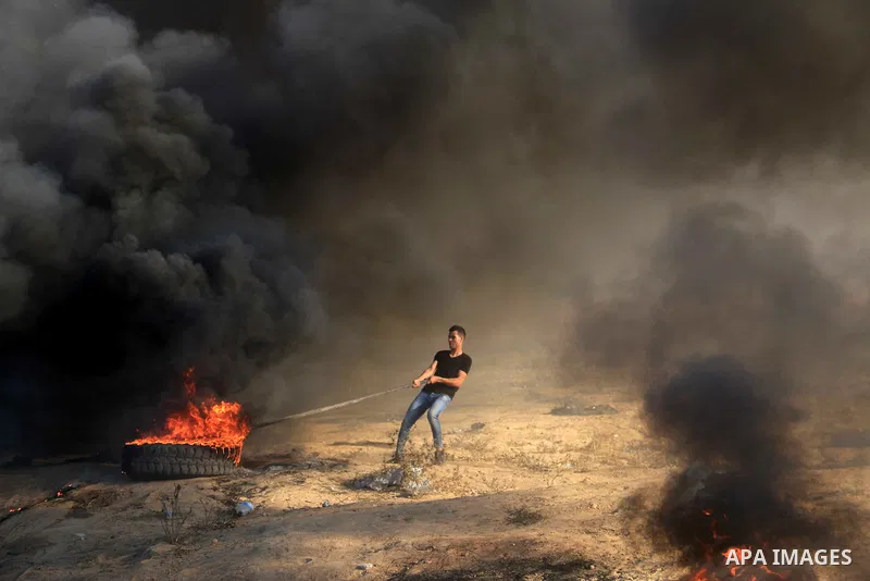 Palestinian protesters gather during clashes with Israeli troops in tents protest where Palestinians demand the right to return to their homeland at the Israel-Gaza border, in al-Bureij in the center of Gaza Strip on Sep...