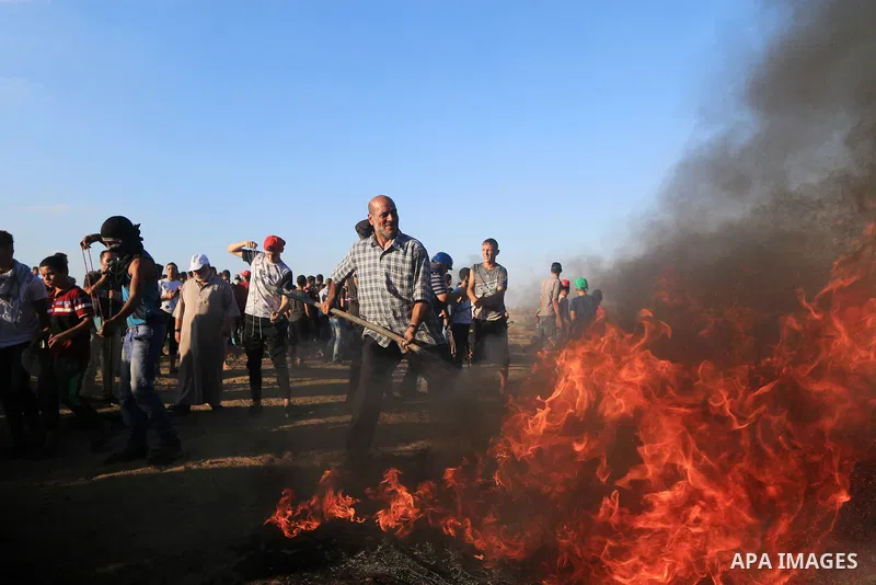 Palestinian protesters gather during clashes with Israeli troops in tents protest where Palestinians demand the right to return to their homeland at the Israel-Gaza border, in al-Bureij in the center of Gaza Strip on Sep...