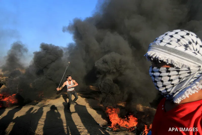 Palestinian protesters gather during clashes with Israeli troops in tents protest where Palestinians demand the right to return to their homeland at the Israel-Gaza border, in al-Bureij in the center of Gaza Strip on Sep...