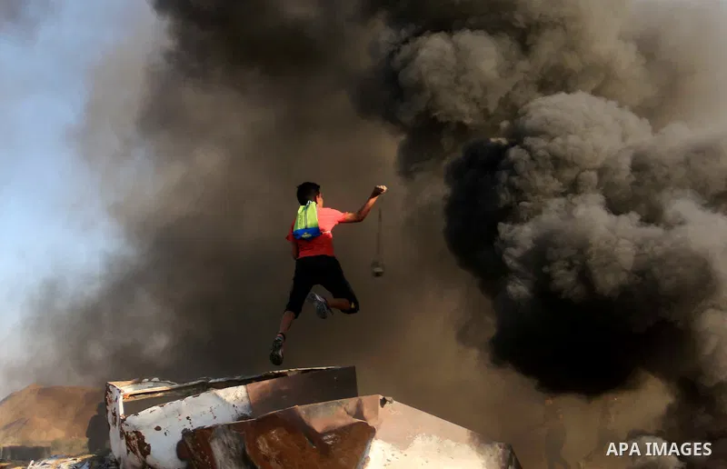 Palestinian protesters gather during clashes with Israeli troops in tents protest where Palestinians demand the right to return to their homeland at the Israel-Gaza border, in al-Bureij in the center of Gaza Strip on Sep...