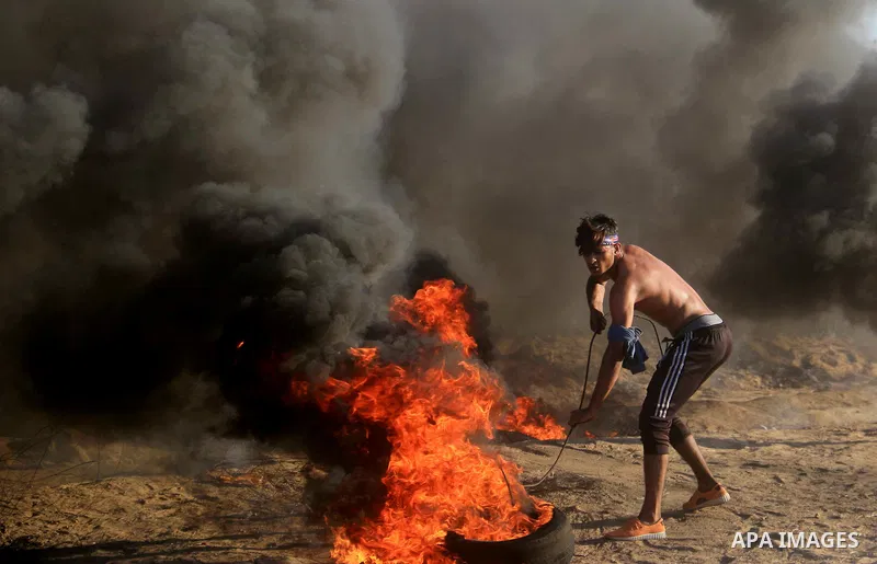 Palestinian protesters gather during clashes with Israeli troops in tents protest where Palestinians demand the right to return to their homeland at the Israel-Gaza border, in al-Bureij in the center of Gaza Strip on Sep...