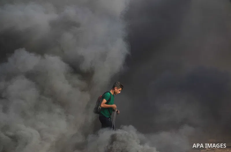 Palestinian protesters gather during clashes with Israeli troops in tents protest where Palestinians demand the right to return to their homeland at the Israel-Gaza border, in al-Bureij in the center of Gaza Strip on Sep...