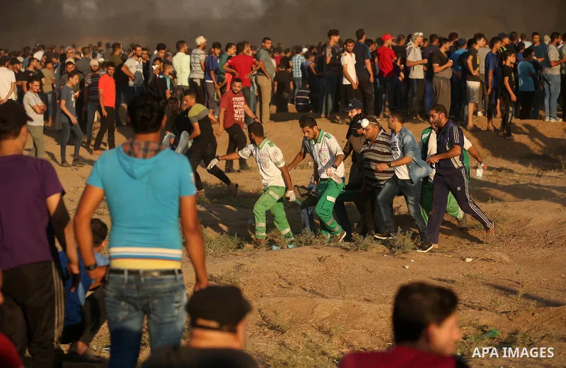 Palestinian protesters gather during clashes with Israeli troops in tents protest where Palestinians demand the right to return to their homeland at the Israel-Gaza border, in east of Gaza City on September 21, 2018. Pho...