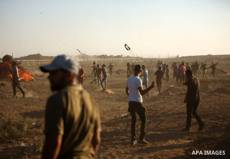 Palestinian protesters gather during clashes with Israeli troops in tents protest where Palestinians demand the right to return to their homeland at the Israel-Gaza border, in east of Gaza City on September 21, 2018. Pho...