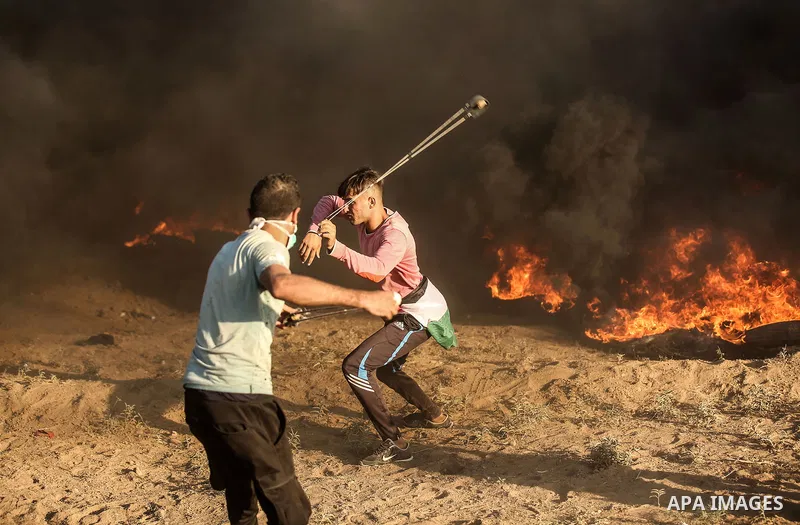 Palestinian protesters gather during clashes with Israeli troops in tents protest where Palestinians demand the right to return to their homeland at the Israel-Gaza border, in east of Gaza City on September 21, 2018. Pho...