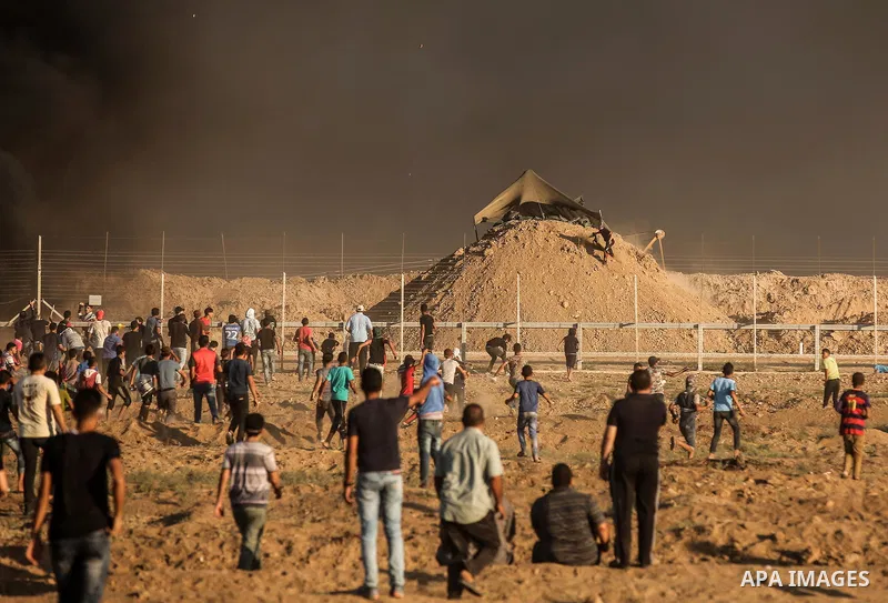 Palestinian protesters gather during clashes with Israeli troops in tents protest where Palestinians demand the right to return to their homeland at the Israel-Gaza border, in east of Gaza City on September 21, 2018. Pho...
