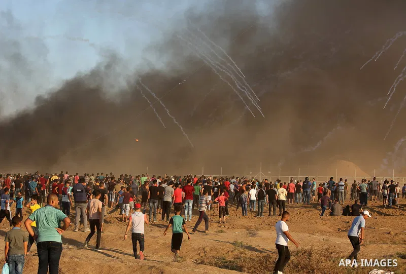 Palestinian protesters gather during clashes with Israeli troops in tents protest where Palestinians demand the right to return to their homeland at the Israel-Gaza border, in east of Gaza City on September 21, 2018. Pho...
