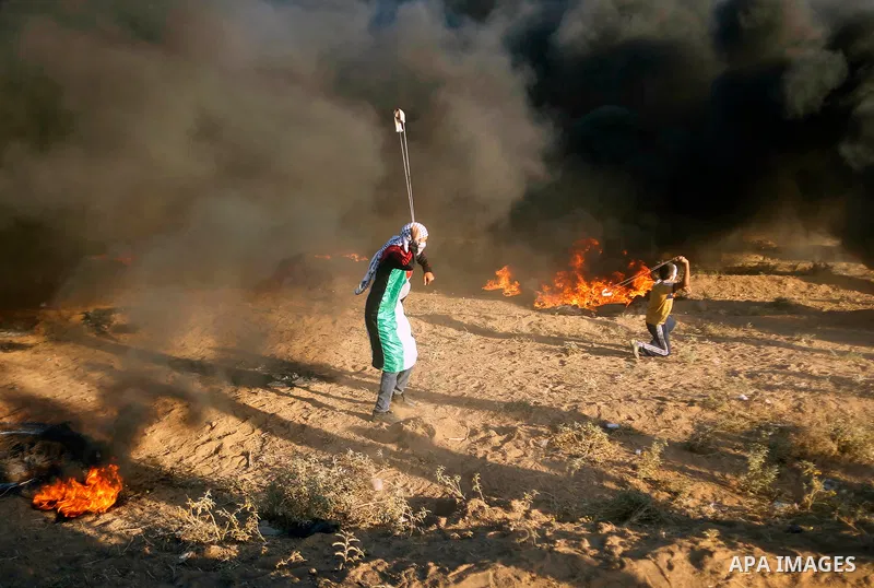 Palestinian protesters gather during clashes with Israeli troops in tents protest where Palestinians demand the right to return to their homeland at the Israel-Gaza border, in east of Gaza City on September 21, 2018. Pho...