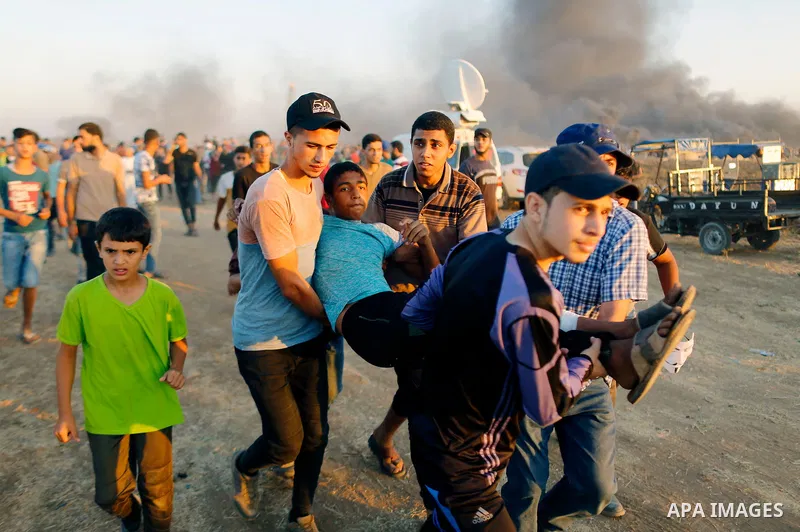 Palestinian protesters gather during clashes with Israeli troops in tents protest where Palestinians demand the right to return to their homeland at the Israel-Gaza border, in east of Gaza City on September 21, 2018. Pho...