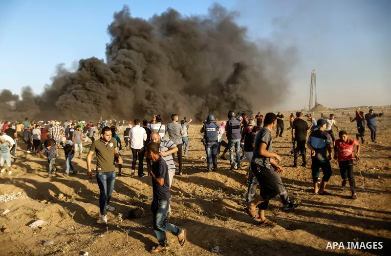 Palestinian protesters gather during clashes with Israeli troops in tents protest where Palestinians demand the right to return to their homeland at the Israel-Gaza border, in east of Gaza City on September 21, 2018. Pho...