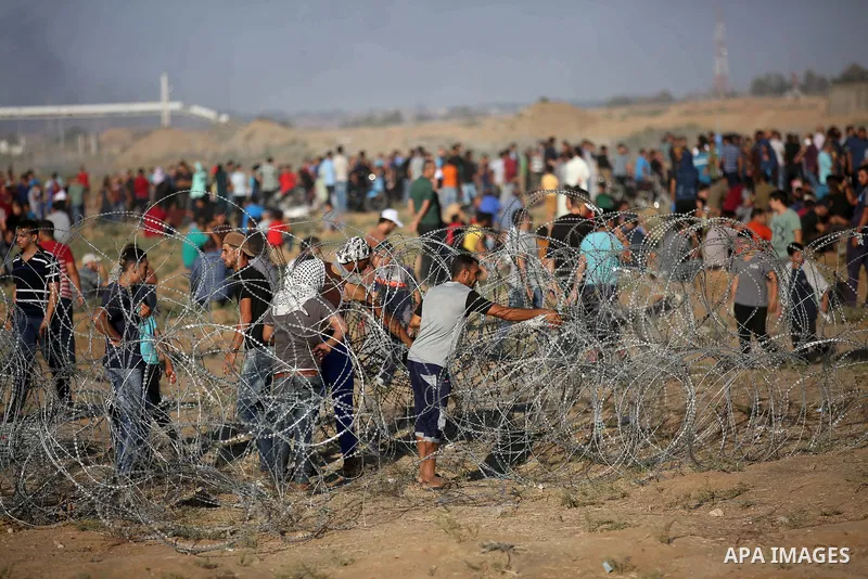 Palestinian protesters gather during clashes with Israeli troops in tents protest where Palestinians demand the right to return to their homeland at the Israel-Gaza border, in east of Gaza City on September 21, 2018. Pho...