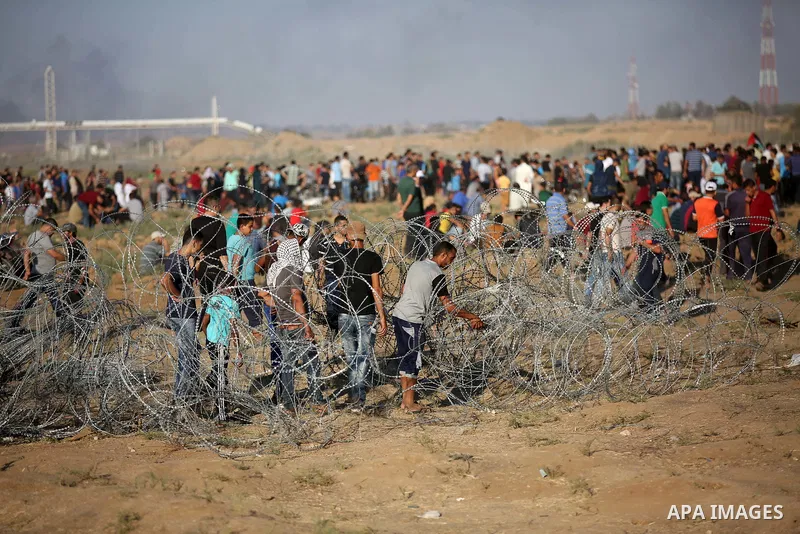 Palestinian protesters gather during clashes with Israeli troops in tents protest where Palestinians demand the right to return to their homeland at the Israel-Gaza border, in east of Gaza City on September 21, 2018. Pho...