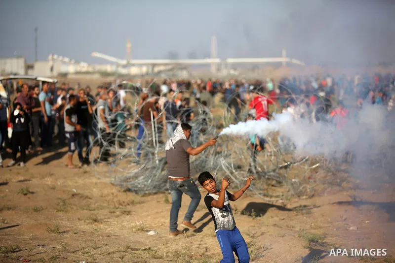 Palestinian protesters gather during clashes with Israeli troops in tents protest where Palestinians demand the right to return to their homeland at the Israel-Gaza border, in east of Gaza City on September 21, 2018. Pho...
