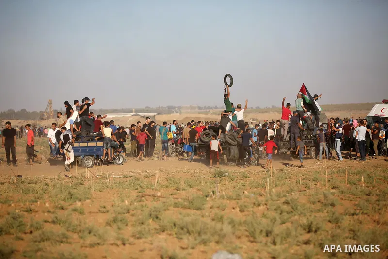 Palestinian protesters gather during clashes with Israeli troops in tents protest where Palestinians demand the right to return to their homeland at the Israel-Gaza border, in east of Gaza City on September 21, 2018. Pho...