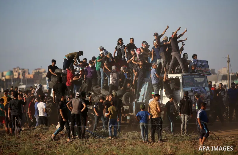 Palestinian protesters gather during clashes with Israeli troops in tents protest where Palestinians demand the right to return to their homeland at the Israel-Gaza border, in east of Gaza City on September 21, 2018. Pho...