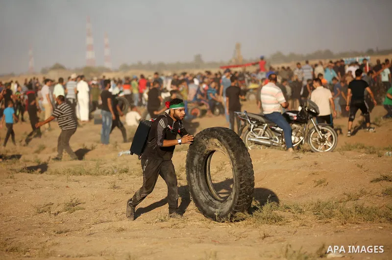 Palestinian protesters gather during clashes with Israeli troops in tents protest where Palestinians demand the right to return to their homeland at the Israel-Gaza border, in east of Gaza City on September 21, 2018. Pho...