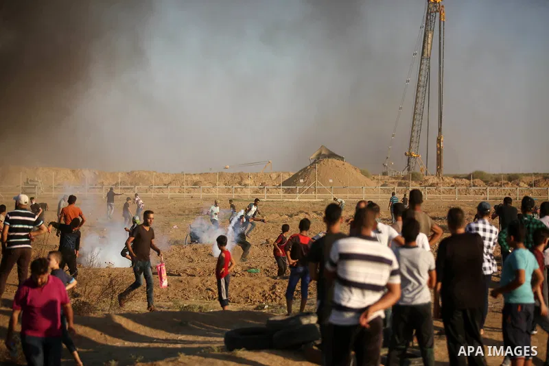 Palestinian protesters gather during clashes with Israeli troops in tents protest where Palestinians demand the right to return to their homeland at the Israel-Gaza border, in east of Gaza City on September 21, 2018. Pho...
