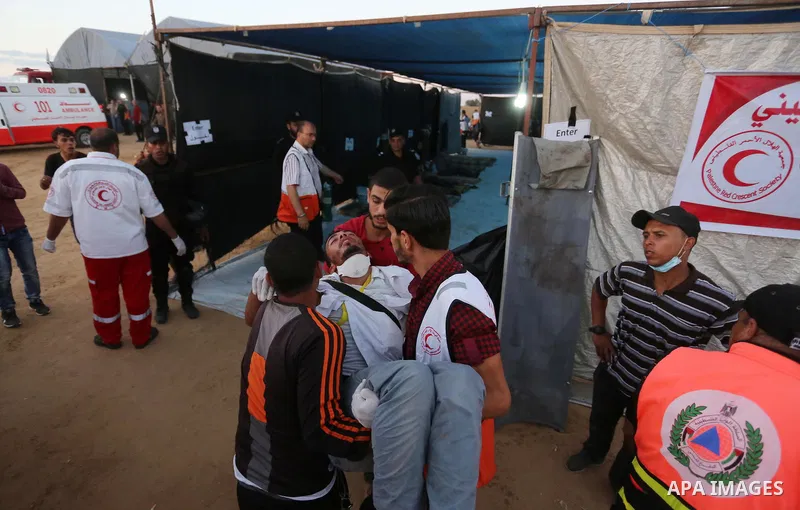 Wounded Palestinian protesters receive treatment in a medical tent during clashes with Israeli troops in tents protest where Palestinians demand the right to return to their homeland at the Israel-Gaza border, in Khan Yo...