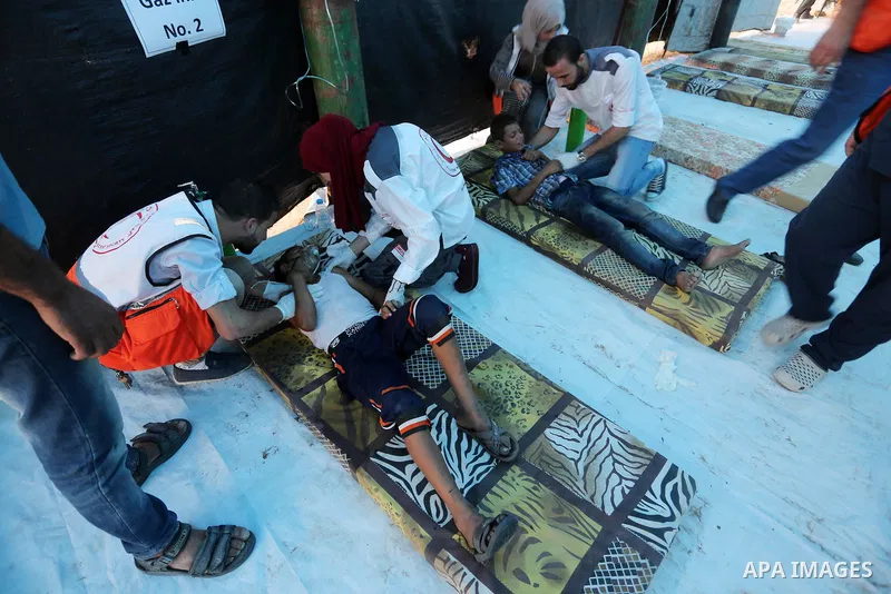 Wounded Palestinian protesters receive treatment in a medical tent during clashes with Israeli troops in tents protest where Palestinians demand the right to return to their homeland at the Israel-Gaza border, in Khan Yo...
