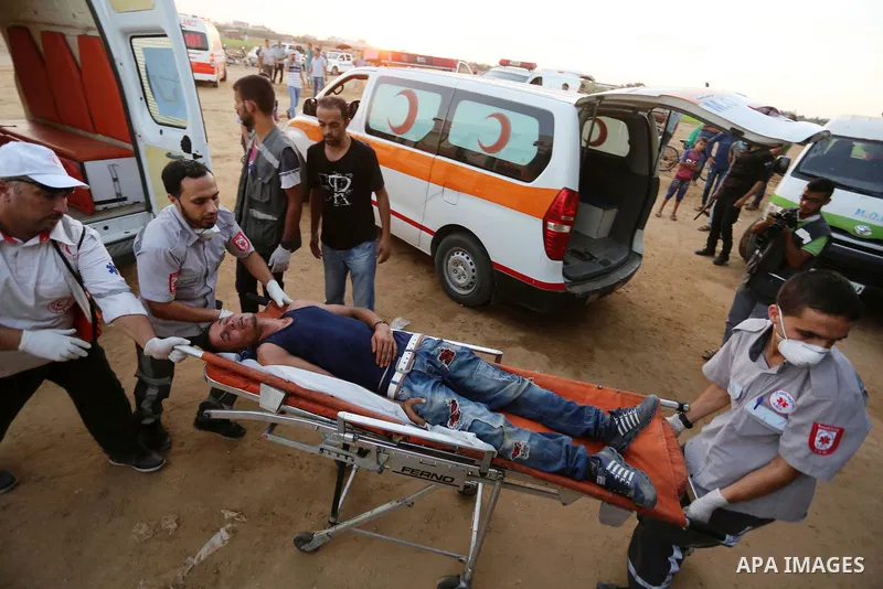 Wounded Palestinian protesters receive treatment in a medical tent during clashes with Israeli troops in tents protest where Palestinians demand the right to return to their homeland at the Israel-Gaza border, in Khan Yo...