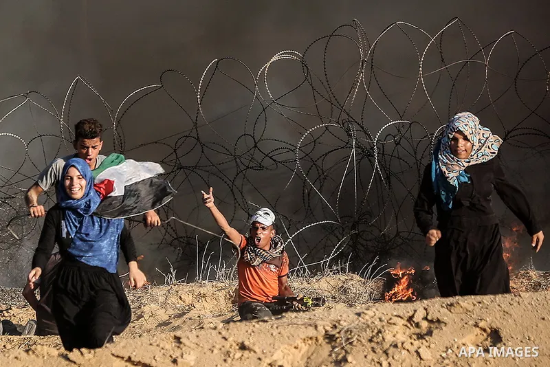 Palestinian protesters gather during clashes with Israeli troops in tents protest where Palestinians demand the right to return to their homeland at the Israel-Gaza border, in Rafah in the southern of Gaza Strip on Septe...