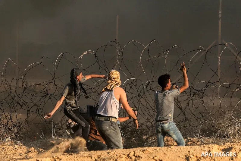 Palestinian protesters gather during clashes with Israeli troops in tents protest where Palestinians demand the right to return to their homeland at the Israel-Gaza border, in Rafah in the southern of Gaza Strip on Septe...