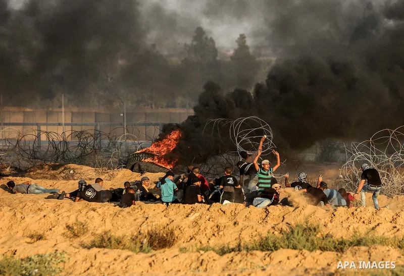 Palestinian protesters gather during clashes with Israeli troops in tents protest where Palestinians demand the right to return to their homeland at the Israel-Gaza border, in Rafah in the southern of Gaza Strip on Septe...