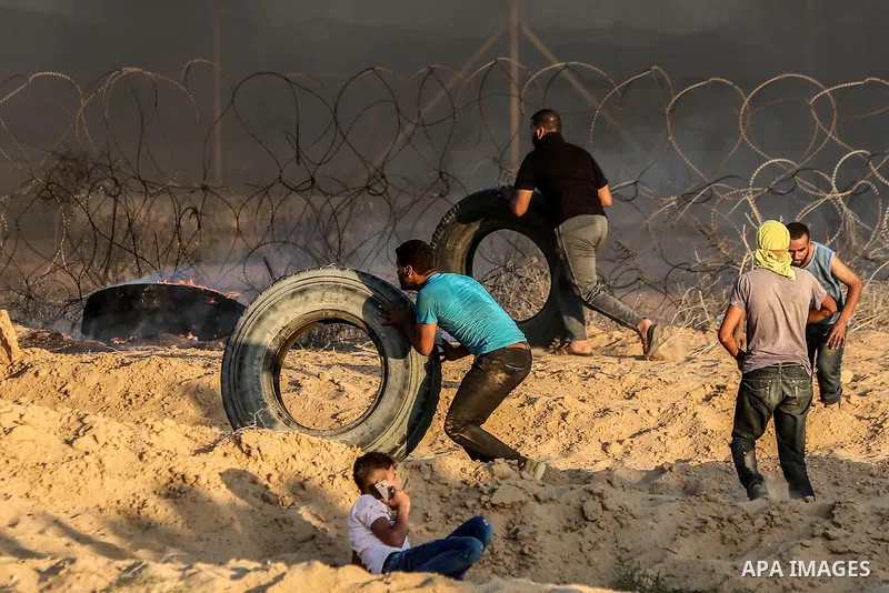 Palestinian protesters gather during clashes with Israeli troops in tents protest where Palestinians demand the right to return to their homeland at the Israel-Gaza border, in Rafah in the southern of Gaza Strip on Septe...