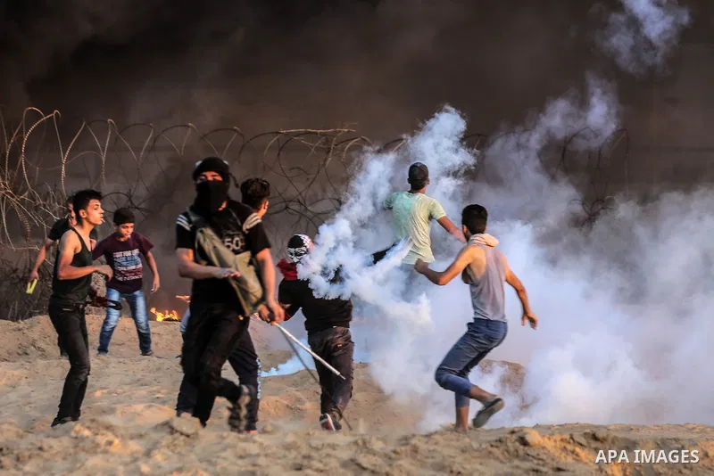 Palestinian protesters gather during clashes with Israeli troops in tents protest where Palestinians demand the right to return to their homeland at the Israel-Gaza border, in Rafah in the southern of Gaza Strip on Septe...