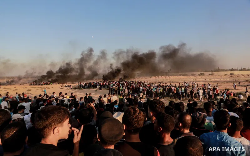 Palestinian protesters gather during clashes with Israeli troops in tents protest where Palestinians demand the right to return to their homeland at the Israel-Gaza border, in Rafah in the southern of Gaza Strip on Septe...