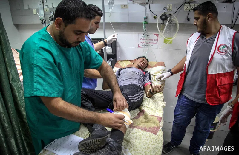 A Palestinian man who was wounded by Israeli troops during clashes at the Israel-Gaza border, in a tent city protest where Palestinians demand the right to return to their homeland, receives treatment at a hospital, in t...