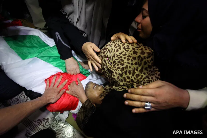 Relatives of Palestinian Kareem Kullab, 25, who was shot dead by Israeli forces during clashes in tents protest where Palestinians demand the right to return to their homeland at the Israel-Gaza border, mourn over his bo...