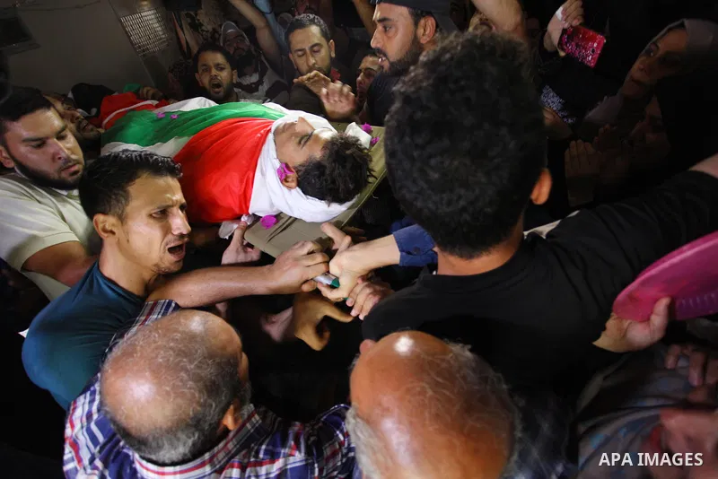 Mourners carry the body of Palestinian Kareem Kullab, 25, who was shot dead by Israeli forces during clashes in tents protest where Palestinians demand the right to return to their homeland at the Israel-Gaza border, dur...