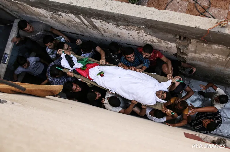 Mourners carry the body of Palestinian Kareem Kullab, 25, who was shot dead by Israeli forces during clashes in tents protest where Palestinians demand the right to return to their homeland at the Israel-Gaza border, dur...