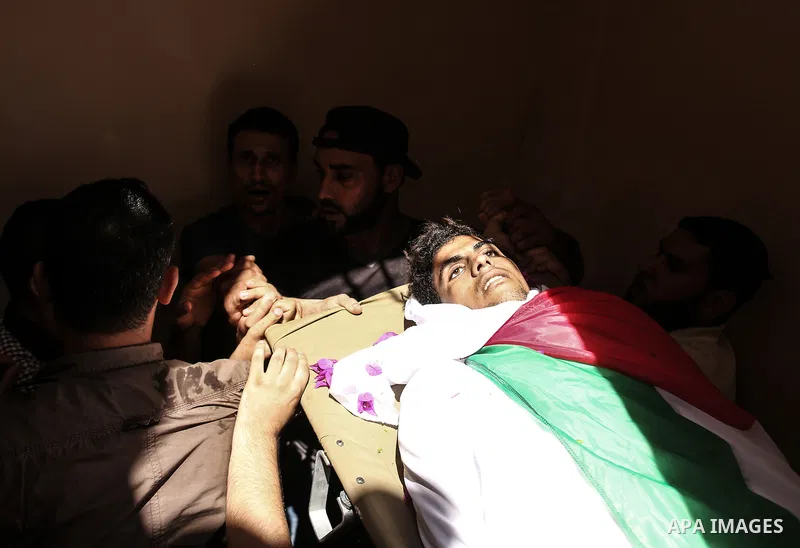 Mourners carry the body of Palestinian Kareem Kullab, 25, who was shot dead by Israeli forces during clashes in tents protest where Palestinians demand the right to return to their homeland at the Israel-Gaza border, dur...
