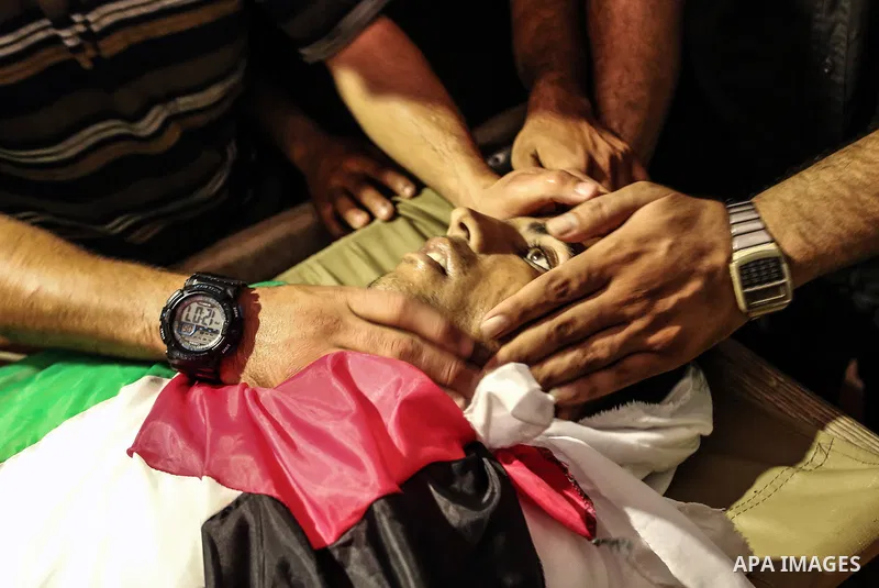 Relatives of Palestinian Kareem Kullab, 25, who was shot dead by Israeli forces during clashes in tents protest where Palestinians demand the right to return to their homeland at the Israel-Gaza border, mourn over his bo...
