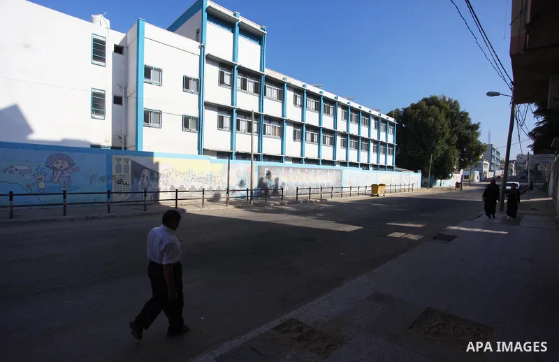 Palestinians walk past the closed gates of the headquarters United Nations Relief and Works Agency (UNRWA) during a strike in Gaza City, on September 24, 2018. Photo by Mahmoud Ajour