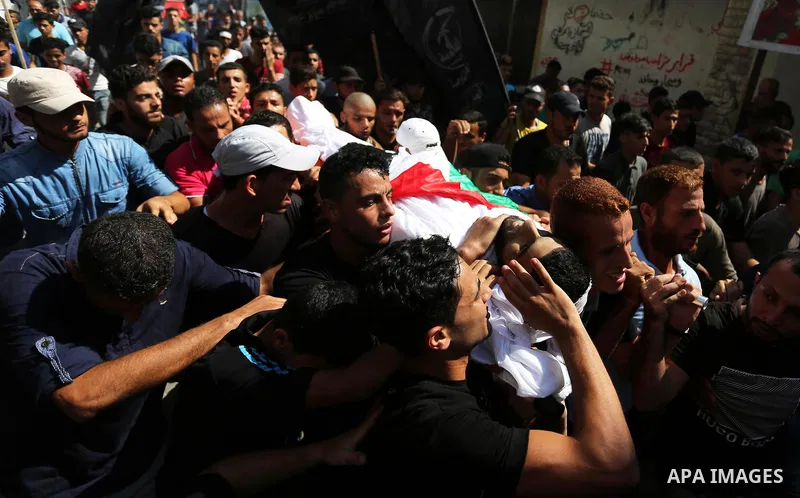 Mourners carry the body of Palestinian Mohamed Abu Sadek, 21, who was shot dead by Israeli forces during clashes at the Israel-Gaza border, during his funeral in Gaza City on September 25, 2018. Photo by Ashraf Amra
