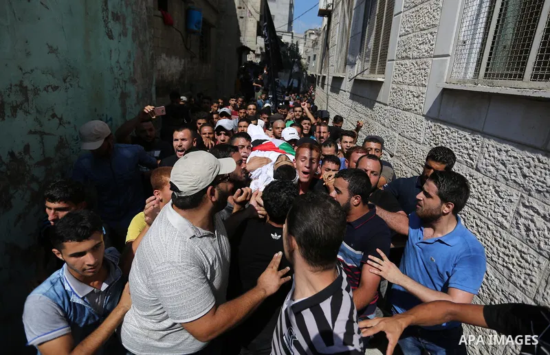 Mourners carry the body of Palestinian Mohamed Abu Sadek, 21, who was shot dead by Israeli forces during clashes at the Israel-Gaza border, during his funeral in Gaza City on September 25, 2018. Photo by Ashraf Amra