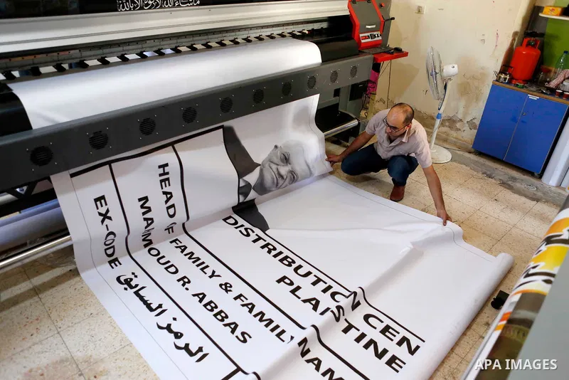 A Palestinian worker prints the largest refugee card for Palestinian President Mahmoud Abbas, to support him before his speech at the United Nations, in the West Bank city of Bethlehem on September 25, 2018. Photo by Wis...
