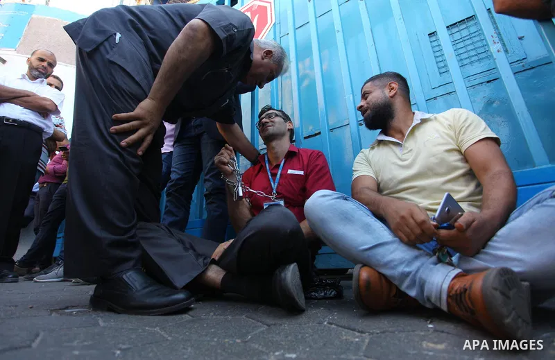 Palestinian employees of United Nations Relief and Works Agency (UNRWA) take part in a protest against job cuts by UNRWA, outside its headquarter office, in Gaza City, on September 27, 2018. Photo by Mahmoud Ajour