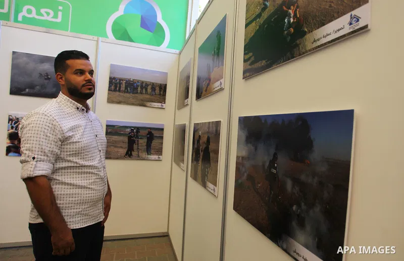 Palestinians attend photos gallery entitled "Journalists on the Line of Fire", in Gaza city on September, 27, 2018. Photo by Mahmoud Ajour