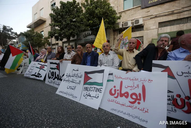 Palestinians hold a poster of president Mahmoud Abbas during a rally in support of Abbas, in Hebron, in the occupied West Bank September 27, 2018. Photo by Wisam Hashlamoun