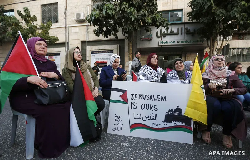 Palestinians hold a poster of president Mahmoud Abbas during a rally in support of Abbas, in Hebron, in the occupied West Bank September 27, 2018. Photo by Wisam Hashlamoun