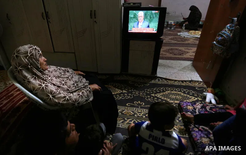 Palestinians watch their President Mahmoud Abbas on TV as he delivers his speech at the General Assembly of the United Nations, in Gaza City, Sept. 27, 2018. Photo by Ashraf Amra