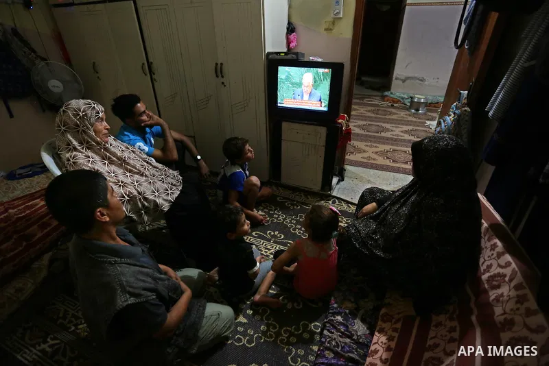 Palestinians watch their President Mahmoud Abbas on TV as he delivers his speech at the General Assembly of the United Nations, in Gaza City, Sept. 27, 2018. Photo by Ashraf Amra