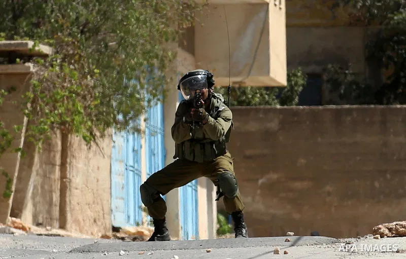 An Israeli soldier takes position during clashes with Palestinian protesters following a weekly demonstration against the expropriation of Palestinian land by Israel in the village of Kfar Qaddum, near the West Bank city...