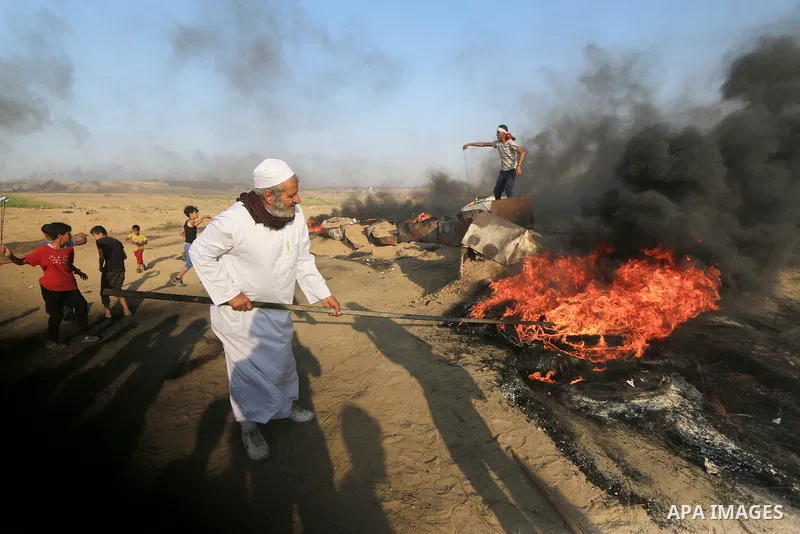 Palestinian protesters gather during clashes with Israeli troops in tents protest where Palestinians demand the right to return to their homeland at the Israel-Gaza border, in al-Bureij in the center of Gaza Strip on Sep...